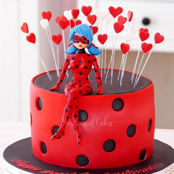 a cake with a Miraculous Ladybug Cake on top