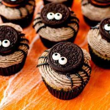 a group of halloween cupcakes with cookies and spiders