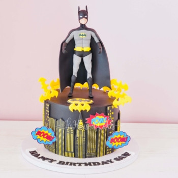 a cake with a superhero Batman figure on top