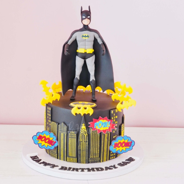 a cake with a superhero Batman figure on top