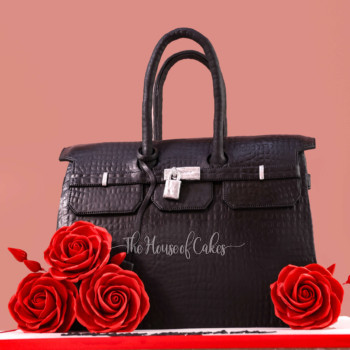 a black Hermes purse cake with red roses