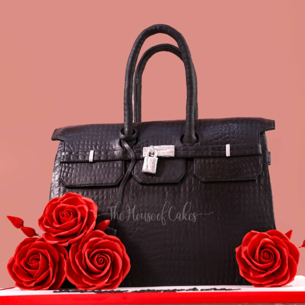 a black Hermes purse cake with red roses