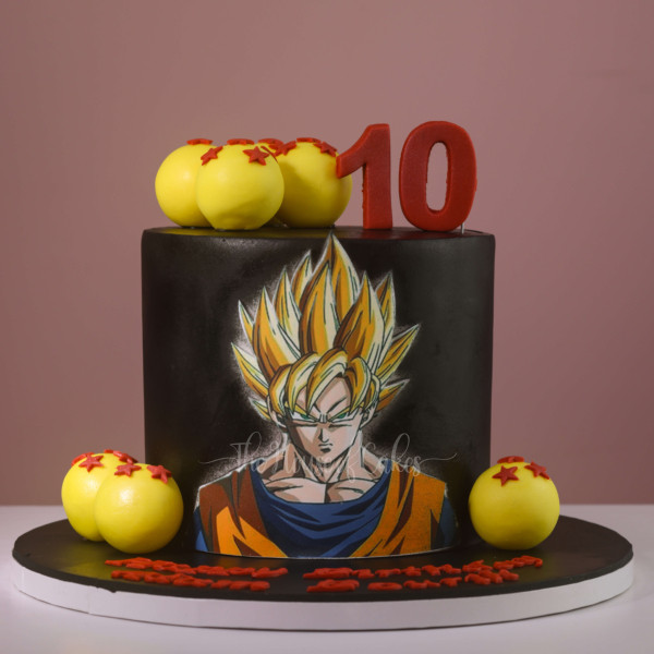 a cake with yellow balls and a cartoon character Goku on it