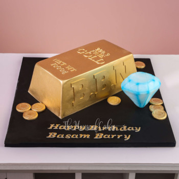 a gold bar cake and a diamond on a black board