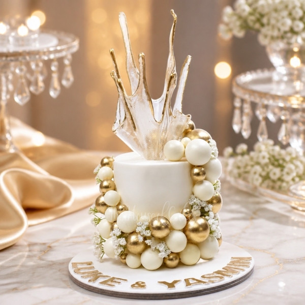 Cake with White and Gold Balls and Sail on Top