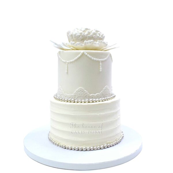Pretty white cake with lace and flower