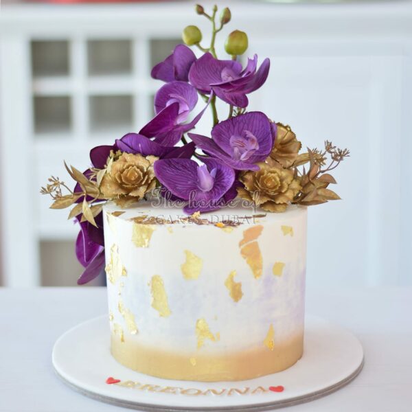 Cake with gold accents and purple orchids