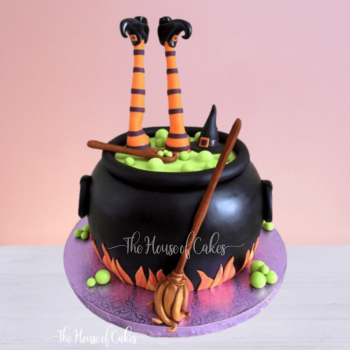 a person's legs in a cauldron halloween cake
