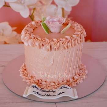 a peach cream cake with a rose on top