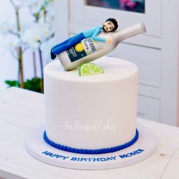 a cake with a guy and corona beer on top